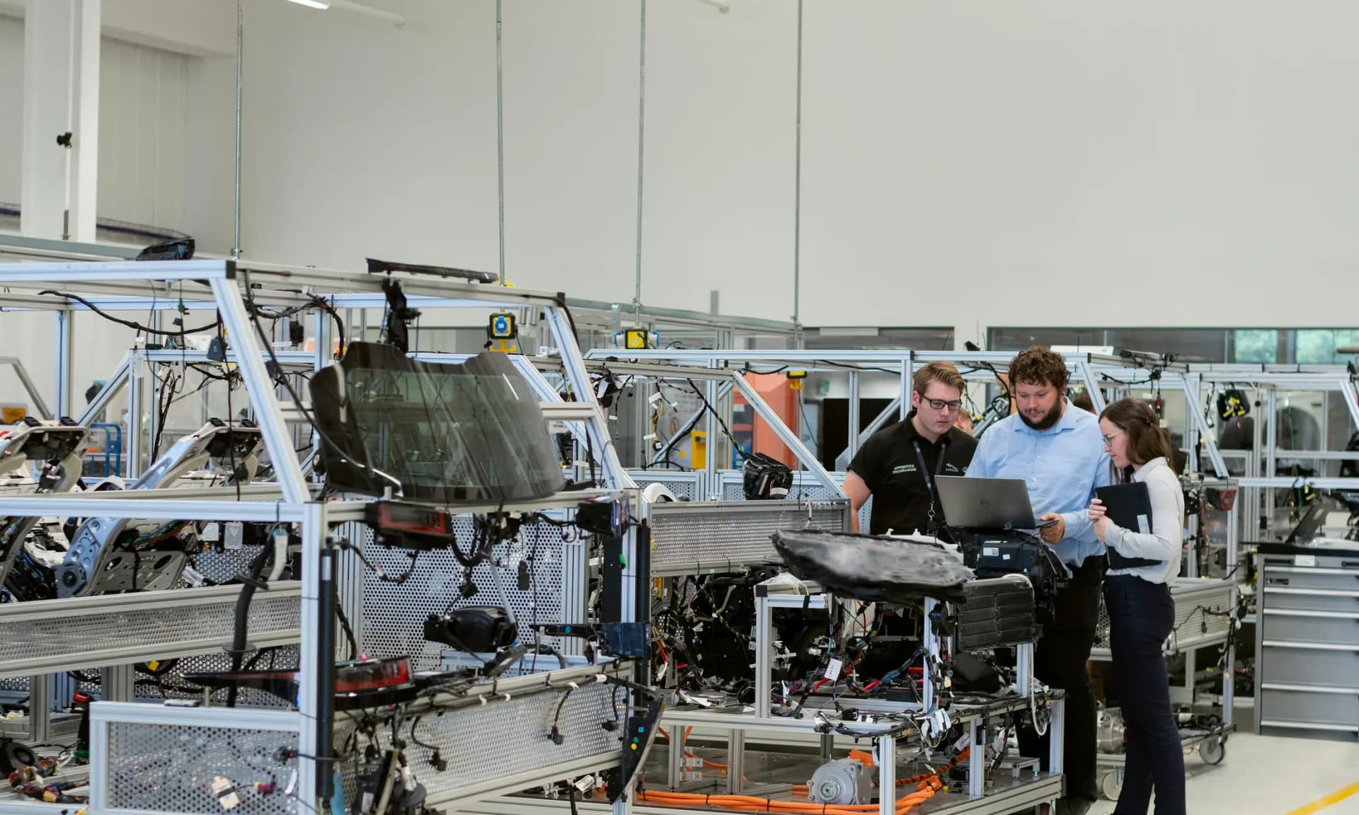 Engineers reviewing a production line and sourcing plan inside a bright factory