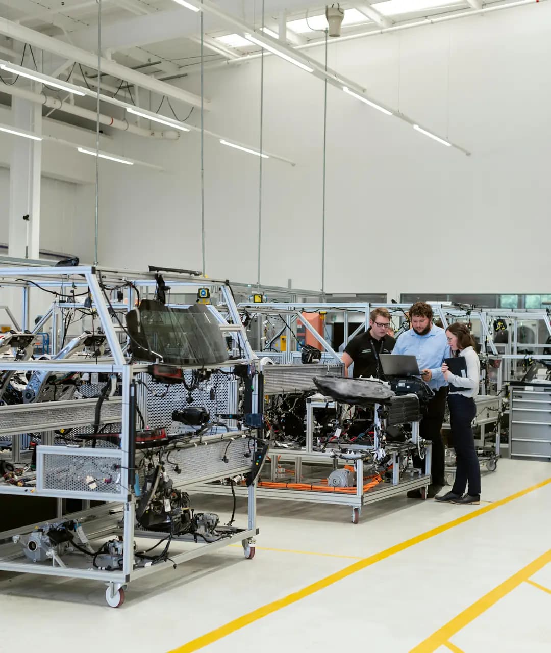 Procurement team reviewing factory details around a laptop and machine frame
