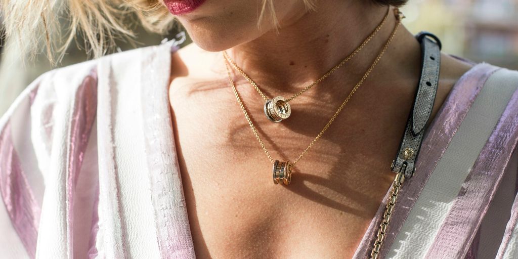 woman wearing gold-colored ring pendant necklaces